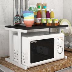 a microwave oven sitting on top of a counter next to dishes and utensils