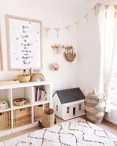 a white room with baskets, bookshelves and other items on the floor in front of a window