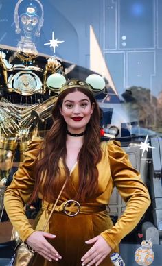 a woman standing in front of a window with an alien head on it's head