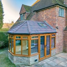 an orange brick building with a tiled roof and glass doors on the side of it