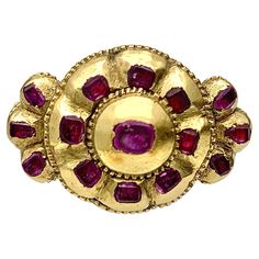 This mid-eighteenth century ring is set with flat cut rubies. The ring head in the shape of a rosette is set with eight small and one large ruby. The larger center stone in a dome shaped closed mount is riveted to the ring head. each ring shoulder is decorated with three rubies and a Bourbon lily. On the outside of the original ring shank on can see an unidentified mark. The ring shank has never been sized. As a collectors piece it would be nice to keep it in it's original state. In the eighteen Ring Ruby, Ring Shank, Two Fingers, Ancient Jewelry, Domed Ring, Be Nice, 18th Century, Bourbon, Gold Ring