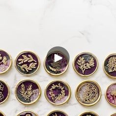 a bunch of buttons sitting on top of a white table next to a black and gold object