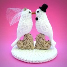 two crocheted birds kissing on top of each other