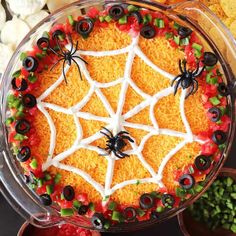 a spider web cake is decorated with candy and sprinkles for halloween decorations