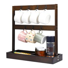 PRICES MAY VARY. Stylish & Practical: Regal Trunk's wooden coffee mug holder stand is a perfect blend of style and functionality, offering a chic display for your mugs. DURABLE CRAFTSMANSHIP : Crafted from a harmonious blend of wooden and iron materials, this holder ensures lasting quality, allowing you to proudly showcase your coffee mugs for years to come. MAXIMIZE SPACE EFFICIENTLY : This mug holder stand has 7 hooks that can hang mugs, coffee cups or tea cups etc. ORGANIZED AND TIDY : Keep your kitchen neat and orderly with this space-saving solution, ensuring efficient and easy access to your favorite mugs and all the essentials you need for your daily brew. IDEAL FIT : Measuring 17x17x6 inches, our Coffee Mug Stand offers a compact yet capacious storage solution, bringing both style Coffee Mug Display On Counter, Coffee Organizer, Coffee Cup Storage, Small Kitchen Items, Coffee Essentials, Coffee Organization, Coffee Mug Display, Shelf With Hooks, Coffee Mug Holder