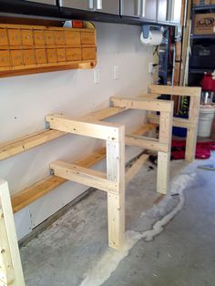 three wooden shelves in a garage with tools on the floor and one shelf is made out of plywood