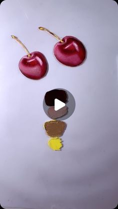 a white plate topped with two cherries and a chocolate chip in the shape of a face