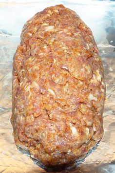 an uncooked meatloaf sitting on top of aluminum foil