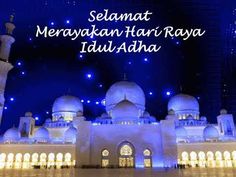 a large white building with lights around it and the words selamat merogan har raya idu adha