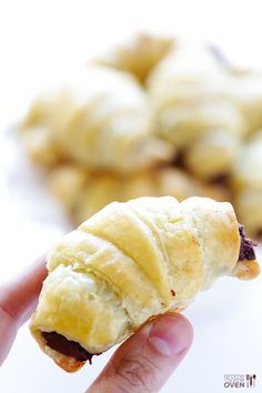 a hand is holding a pastry that looks like a caterpillar