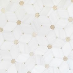 a white and beige tiled wall with hexagonal tiles