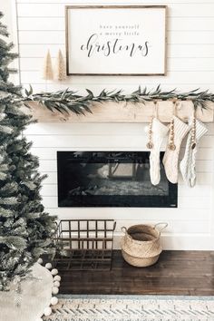 a christmas tree in the corner of a living room with stockings hanging from it's branches