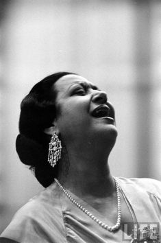 an old photo of a woman singing into a microphone