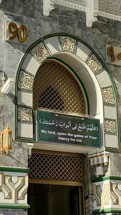 an entrance to a building with arabic writing on the front door and gold trimmings