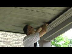 a man is working on the underside of a house's gutter system that has been installed