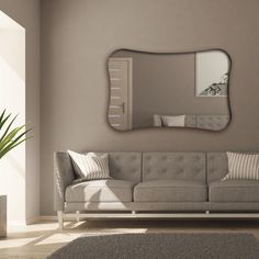 a living room with a couch, mirror and potted plant