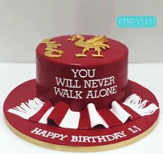 a red cake with white frosting and gold decorations on top that says, you will never walk alone