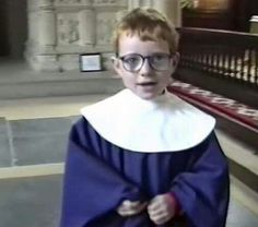 a young boy wearing glasses and a blue cape