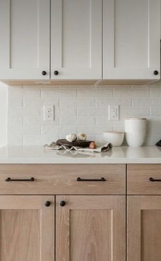 a kitchen with white cabinets and black appliances