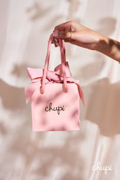 a person holding a pink bag with the word chopp on it