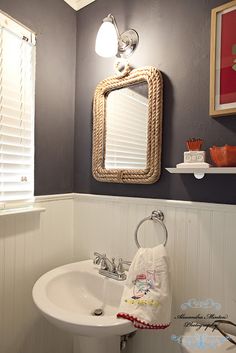 a white sink sitting under a bathroom mirror