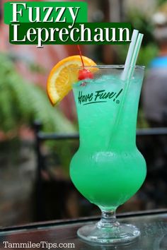 there is a green drink with orange wedges on the rim and a straw in it