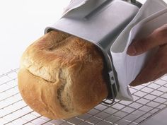 a loaf of bread is being held by a person with an oven mitt on it