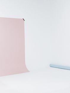 an empty photo studio with a pink backdrop and light blue soft object in the foreground