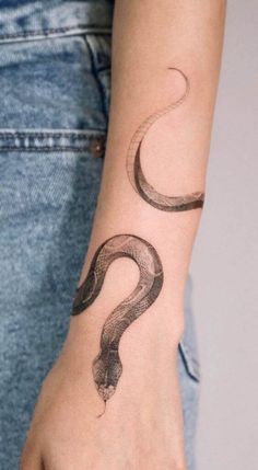 a woman's arm with a snake tattoo on it