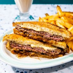 a white plate topped with a sandwich and french fries next to a glass of milk