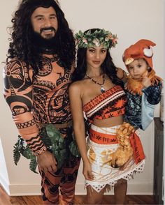 a man and woman dressed up as native american indians, one holding a baby in his arms