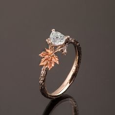 "A hand made twig and leaf ring set with a pear shaped diamond. The ring displays a beautiful twig pattern along with a maple leaf that creates a pleasantly asymmetrical result. A delicate, handmade engagement ring made in two gold colors and set with a natural white diamond of high quality. The grooves in the band are plated with black rhodium which emphasizes the texture. if you prefer not to apply the black rhodium that is fine. I can also use white, rose or yellow gold for the band and the l Twig Engagement Ring Vintage, Engagement Ring Twig Band, Leaf Wedding Ring Pair, Maple Leaf Engagement Ring, Unique Engagement Rings Leaf Band, Moonstone Engagement Ring Leaf, Twig Inspired Engagement Rings, Juniper Leaf Ring, Engagement Ring Leaves Vines