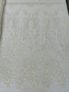 the fabric is white and has gold sequins on it