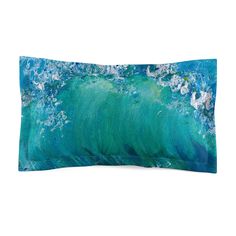 an ocean themed pillow with blue and green waves in the water, on a white background