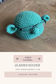 a crocheted turtle with glasses on top of a wooden table