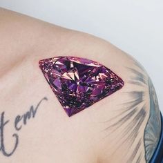 a pink diamond tattoo on the back of a man's shoulder