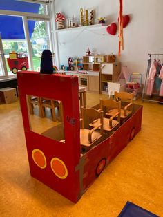 a child's play room with cardboard train and firetruck