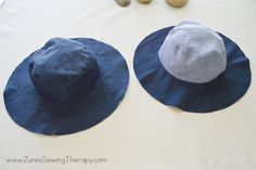 two hats sitting on top of a table next to some rocks and stones in the background