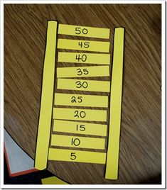 a wooden table topped with lots of yellow numbered numbers next to a knife and fork