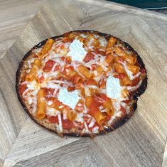 a pizza sitting on top of a wooden cutting board covered in cheese and tomato sauce