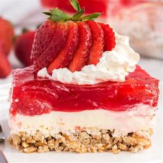 a piece of strawberry cheesecake with whipped cream and strawberries on top