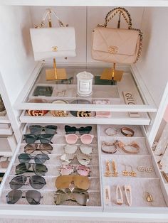 a white closet filled with lots of different types of sunglasses and handbags on display