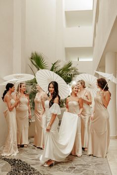 a group of women standing next to each other holding umbrellas