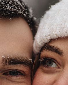 two people are looking at the camera with snow on their faces