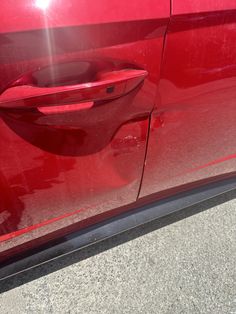 the door handle on a red car that is parked