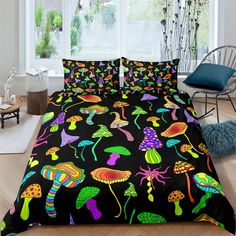 a bed covered in black comforter with colorful mushrooms on it