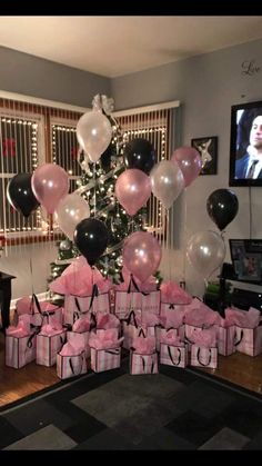 a christmas tree is decorated with balloons and presents for someone's 70th birthday party