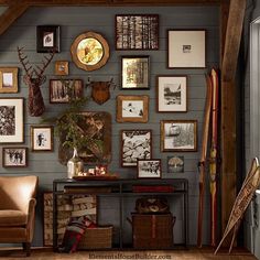 a room filled with lots of framed pictures on the wall next to a brown chair