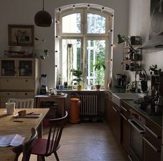 a kitchen filled with lots of counter top space and wooden furniture next to an open window