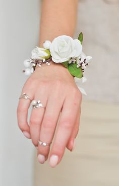 a close up of a person's hand wearing a bracelet with flowers on it